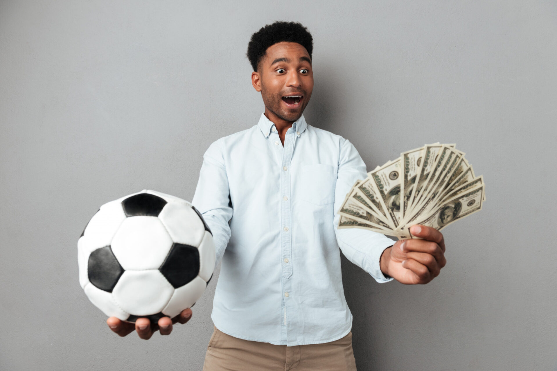 happy-smiling-african-man-showing-football-money-banknotes-1-e1683223077589.jpg